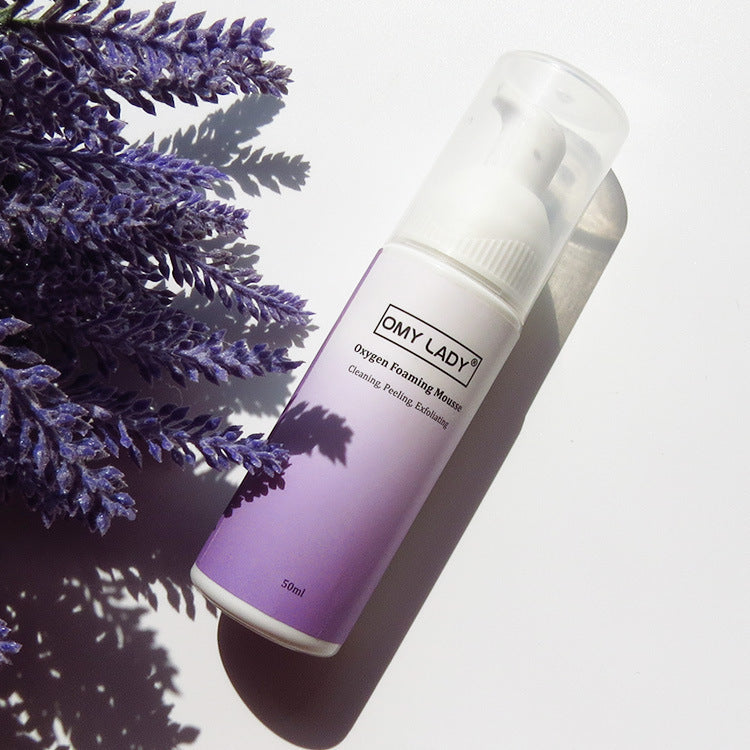 OMY LADY Cleansing Mousse 50ml bottle placed beside lavender, promoting its soothing formula for exfoliating and removing blackheads effectively.